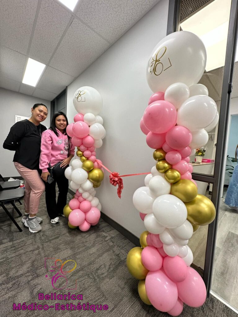 Pair of elegant pink, white, and gold organic balloon columns in Montreal featuring a ceremonial red ribbon for a grand opening or special celebration.